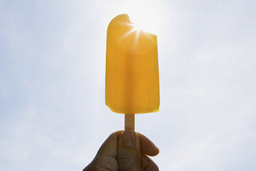 Person mit einem Eislutscher an einem sonnigen Tag - ISF00704