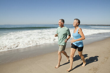 Senior couple jogging on beach - ISF00712