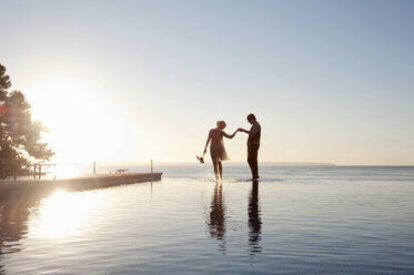 Couple in the ocean at sunset - ISF00727