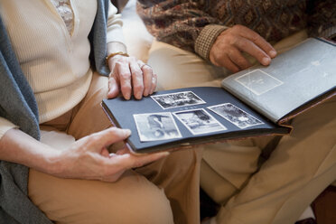Senior couple looking through photo album, mid section - ISF00728