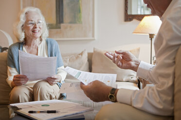 Senior couple discussing paperwork at home - ISF00731