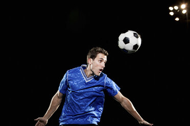 Young man leaping to head soccer ball - ISF00742