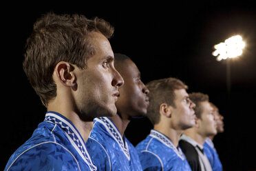Fußballspieler stehen nachts in einer Reihe auf dem Spielfeld - ISF00743
