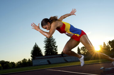 Weibliche Athletin beim Verlassen der Startblöcke - ISF00838