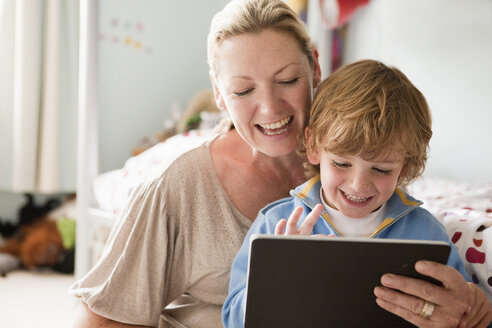 Mother using a digital tablet with her son - ISF00914