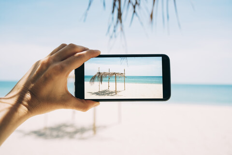 Thailand, Koh Lanta, Virgin Paradise Beach, Frau fotografiert mit Mobiltelefon, lizenzfreies Stockfoto