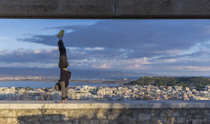 Mann macht Handstand an der Wand, Cagliari, Sardinien, Italien - CUF01902