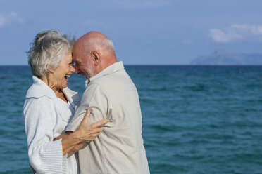 Couple hugging and laughing by seaside - CUF01918