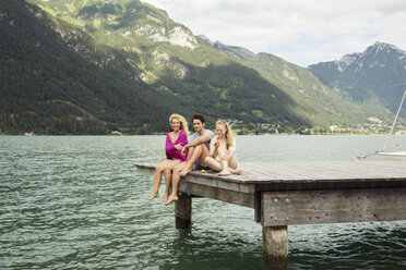 Freunde sitzen zusammen am Rande eines Stegs, Innsbruck, Tirol, Österreich, Europa - CUF01923