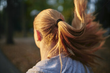 Junge Läuferin mit Pferdeschwanz läuft im Park - CUF01950