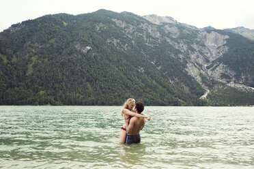 Couple waist deep in water kissing, Achensee, Innsbruck, Tirol, Austria, Europe - CUF01996