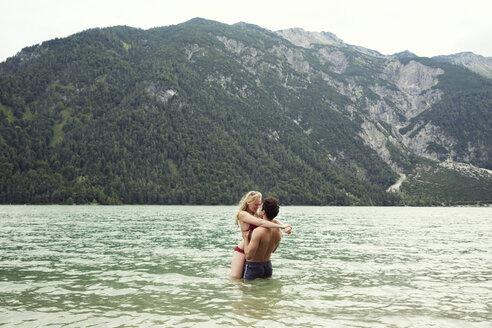 Pärchen hüfttief im Wasser küssend, Achensee, Innsbruck, Tirol, Österreich, Europa - CUF01996