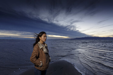 Junge Frau an einem windigen Strand in der Abenddämmerung, Tarragona, Katalonien, Spanien - CUF02010