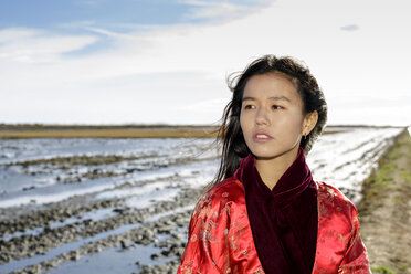 Porträt einer jungen asiatischen Frau am Strand in traditioneller Kleidung, Tarragona, Katalonien, Spanien - CUF02019