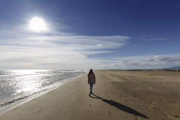 Rear view of young woman strolling along on beach, Tarragona, Catalonia, Spain - CUF02022