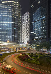 China, Hong Kong, High-rise buildings and taxi at night - MKFF00385