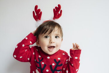 Porträt eines kleinen Mädchens mit Rentiergeweih-Stirnband zur Weihnachtszeit - GEMF01939