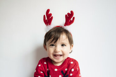Porträt eines lachenden kleinen Mädchens mit Rentiergeweih als Stirnband - GEMF01941