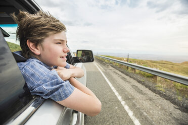 Boy on road trip leaning out of car window - CUF02062