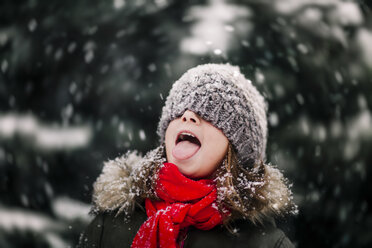 Porträt eines Mädchens, das fallenden Schnee auf der Zunge auffängt - CUF02086