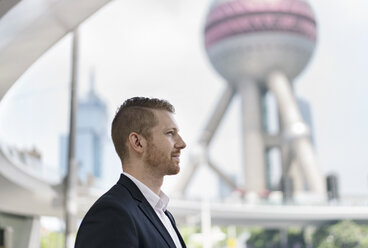 Junger Geschäftsmann mit Blick auf das Finanzzentrum von Shanghai, Shanghai, China - CUF02183