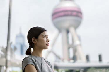 Junge Geschäftsfrau mit Blick auf das Finanzzentrum von Shanghai, Shanghai, China - CUF02186