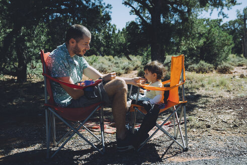 USA, Arizona, Grand Canyon National Park, Vater und Tochter essen im Freien - GEMF01945