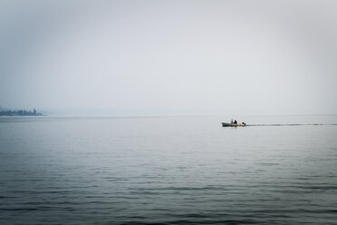 Menschen in einem entfernten Boot auf dem Gardasee, Lazise, Venetien, Italien, Europa - CUF02224