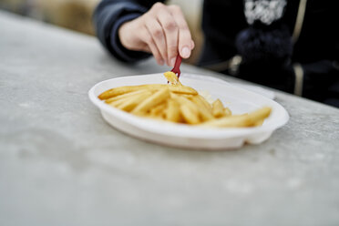 Woman eating French Fries, close-up - MMIF00001