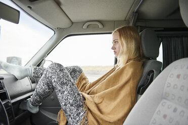 Blonde junge Frau sitzt im Auto und schaut in die Ferne - MMIF00002