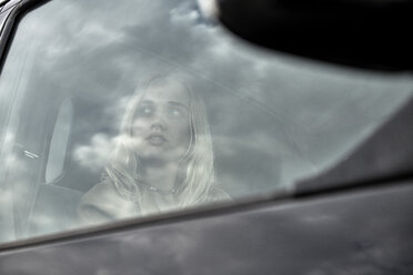 Young woman sitting in a car looking out of window - MMIF00005