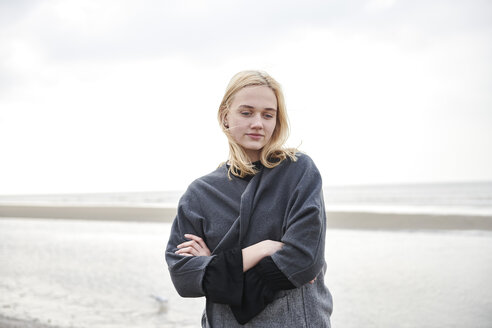 Netherlands, portrait of blond young woman on the beach - MMIF00028