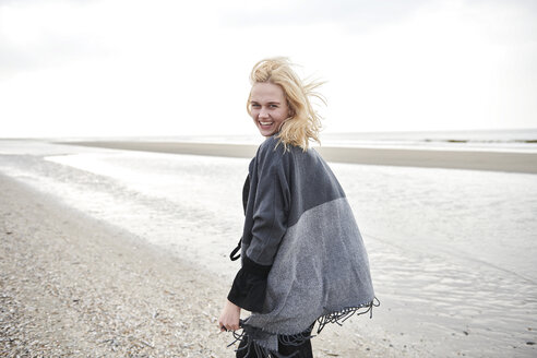 Netherlands, portrait of laughing blond young woman on the beach - MMIF00030