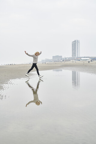 Niederlande, Zandvoort, junge Frau hat Spaß am Strand, lizenzfreies Stockfoto