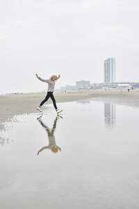 Niederlande, Zandvoort, junge Frau hat Spaß am Strand - MMIF00044