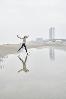 Niederlande, Zandvoort, junge Frau hat Spaß am Strand - MMIF00044