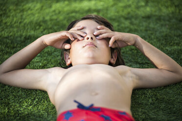 Junge im Gras liegend, Augen zuhaltend - CUF02467