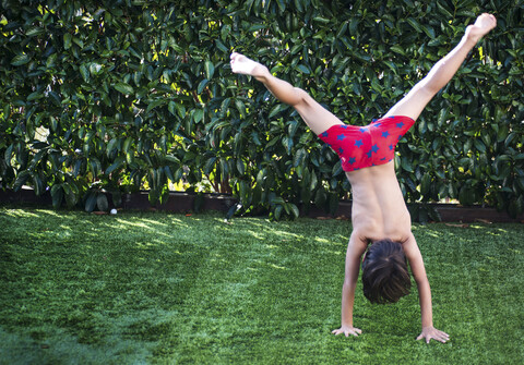 Junge macht Handstand auf Gras, lizenzfreies Stockfoto