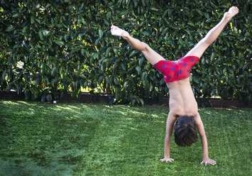 Junge macht Handstand auf Gras - CUF02468