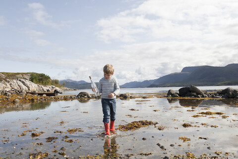 Junge mit Flaschenpost, Aure, More og Romsdal, Norwegen, lizenzfreies Stockfoto