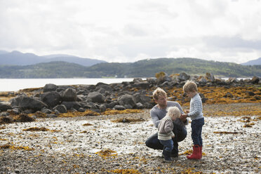 Man with sons looking at nature by fjord, Aure, More og Romsdal, Norway - CUF02520