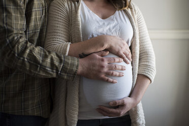 Schwangere Frau berührt Bauch, Partner zeigt Zuneigung, Mittelteil - CUF02552