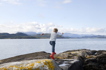 Junge springt über Felsen am Fjord, Aure, More og Romsdal, Norwegen - CUF02560