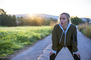 Junge Frau im Freien, die eine Pause vom Sport macht, Hände auf den Knien - CUF02563