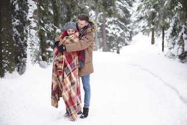 Junges Paar umarmt sich im Schnee - CUF02574