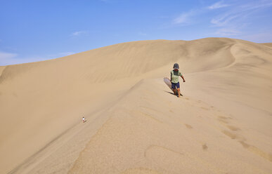 Junge mit Sandboard auf Sanddünen, Ica, Peru - CUF02594