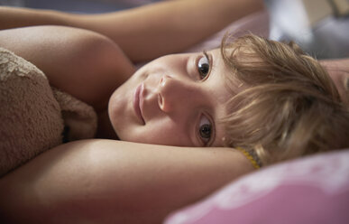 Boy lying in bed with mother, close up portrait - CUF02596