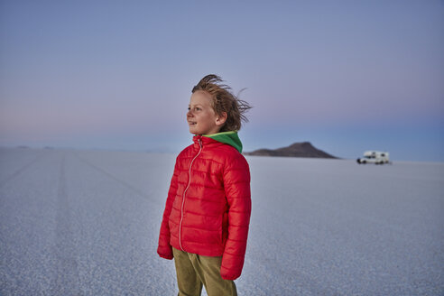 Junge steht auf einer Salzwiese und betrachtet die Aussicht, Wohnmobil im Hintergrund, Salar de Uyuni, Uyuni, Oruro, Bolivien, Südamerika - CUF02614