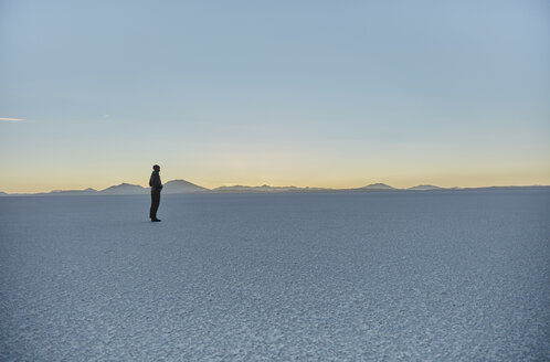 Frau steht auf einer Salzwiese und betrachtet die Aussicht, Salar de Uyuni, Uyuni, Oruro, Bolivien, Südamerika - CUF02621