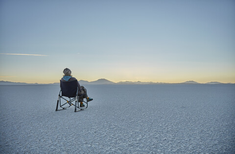 Frau im Campingstuhl sitzend, auf Salzwiese, mit Blick auf Aussicht, Salar de Uyuni, Uyuni, Oruro, Bolivien, Südamerika, lizenzfreies Stockfoto